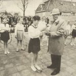 De 84-jarige R. de Jong, oudste nog in leven zijnde oud-leerling van de schooi in Tjerkwerd, ontvangt van één van de leden van een dansgroepje de sleutel van De Regenboog..